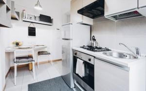 eine kleine weiße Küche mit einem Waschbecken und einem Tisch in der Unterkunft Residenza Begatto in Bologna