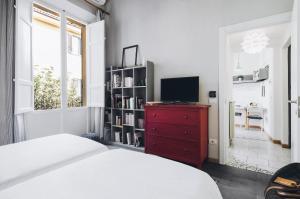Schlafzimmer mit einem Bett, einem TV und einer roten Kommode in der Unterkunft Residenza Begatto in Bologna