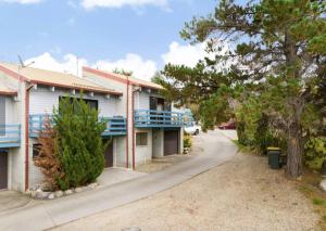 a building with blue balconies and a street at Jindang House - Spacious Three Bedroom Townhouse in Jindabyne