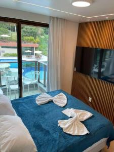 um quarto com uma cama com duas toalhas em RESERVA CARNEIROS BEIRA MAR - BEACH RESORT- DELUX em Praia dos Carneiros