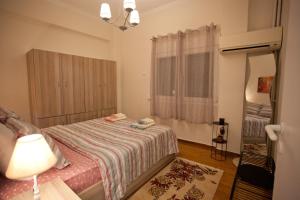 a small bedroom with a bed and a lamp at Lovely Nest Piraeus in Piraeus