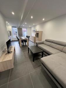 salon z kanapą i stołem w obiekcie maison centre de cassel w mieście Cassel