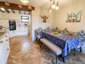 uma cozinha e sala de jantar com mesa e cadeiras em 3 Penllan Cottages em Holywell