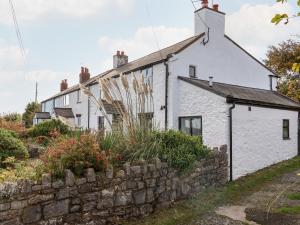 um chalé branco com uma parede de pedra em 3 Penllan Cottages em Holywell