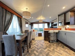 a kitchen and dining room with a table and chairs at The Coorie Neuk Hot Tub Lodge 34 Cameron, St Andrews in St. Andrews