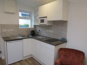 a kitchen with white cabinets and a sink at Lavender Mews in Tuam