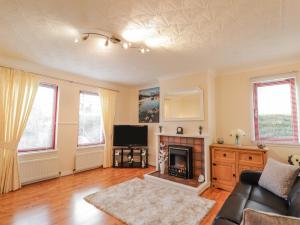 a living room with a couch and a fireplace at 25 Langlands Terrace in Kyle of Lochalsh