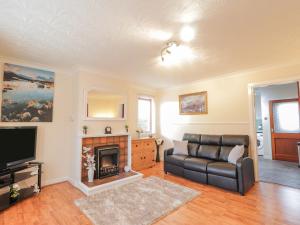- un salon avec un canapé et une cheminée dans l'établissement 25 Langlands Terrace, à Kyle of Lochalsh
