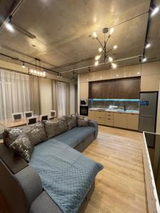 uma ampla sala de estar com um sofá e uma cozinha em Apartment Florence моря 600 метров em Aktau