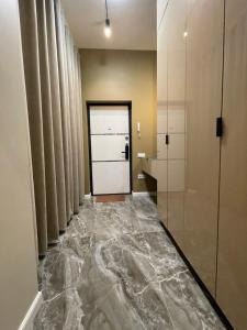 um corredor com piso em mármore num quarto em Apartment Florence моря 600 метров em Aktau
