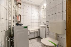 a white bathroom with a toilet and a sink at JAD - Family Studio - Soarelui 8 in Braşov