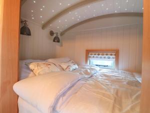 1 dormitorio con 1 cama con sábanas blancas en Herbie's Shepherds Hut, en Nottingham