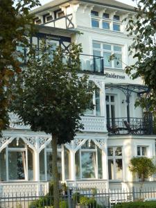 a white building with a tree in front of it at Villa Haiderose in Binz