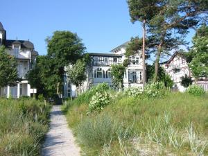 um caminho através de um campo com casas ao fundo em Villa Haiderose em Binz