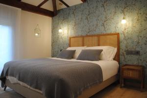 - une chambre avec un grand lit et du papier peint bleu dans l'établissement Hotel a Ecogranxa, à Pontevedra