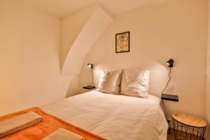Un dormitorio con una cama blanca con dos lámparas. en L'iris #Netflix #Centre-ville, en Cognac
