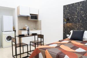 a bedroom with a bed and a small kitchen at Olina residence in Naples