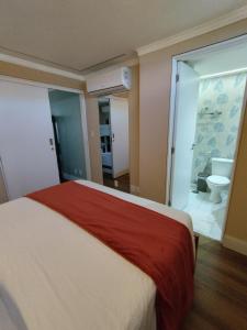 um quarto com uma cama e uma casa de banho com um WC em Luxuoso BEIRA-MAR duas suítes em Maceió