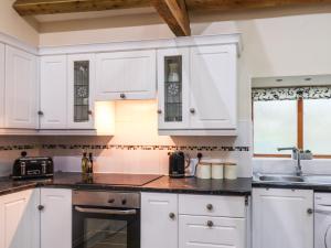 a kitchen with white cabinets and a sink at Sarah's Cottage in Bridlington