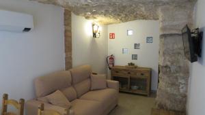 a living room with a couch and a stone wall at Alojamiento Rural Singular Pepe el Tranquilo in Alcalá del Júcar