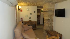 ein Wohnzimmer mit einem Sofa und einem TV in der Unterkunft Casa Rural Pepe el Tranquilo in Alcalá del Júcar