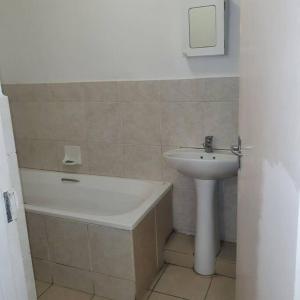 a bathroom with a sink and a bath tub next to a sink at Imanna 111 in Durban