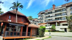 ein Gebäude mit einer Palme vor einem Gebäude in der Unterkunft Flat 217 Granja Brasil - Com Piscina Aquecida Em Itaipava in Itaipava