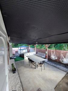 een patio met een witte tafel en stoelen en een bank bij Villa in Baie Mahault