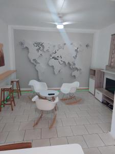 um quarto com cadeiras e um mapa do mundo na parede em lam em Baie Mahault