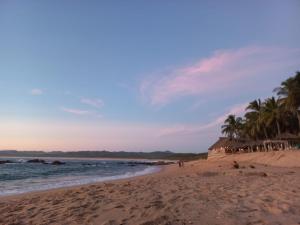 una playa con un grupo de personas y palmeras en Camino al Mar, en Ipala