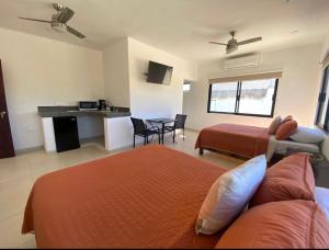 ein Schlafzimmer mit 2 Betten und eine Küche mit einem Tisch in der Unterkunft Villa Paraíso in La Ventana