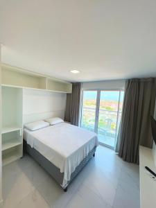 a bedroom with a bed and a large window at Fortaleza Sul Flats Service in Fortaleza