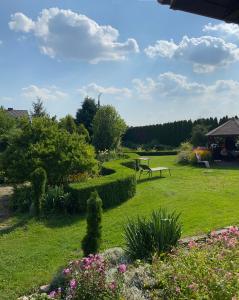 un parco con panchina e fiori nell'erba di Agroturystyka Smulsko a Przykona