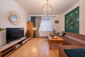 ein Wohnzimmer mit einem großen TV und einem Weihnachtsbaum in der Unterkunft Joya Mia - the soul of Riga & free parking in Riga