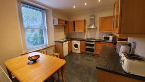 a kitchen with a wooden table and a counter top at Lovely property in Central Broughty Ferry, Dundee in Broughty Ferry