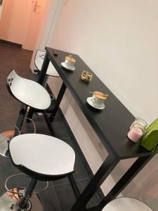 a black table with two chairs and cups on it at Strasbourg «La source de ValAuRa » De l’Eau à l’Or in Strasbourg +16 photos