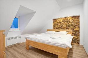 ein Schlafzimmer mit einem Bett mit einer Steinmauer in der Unterkunft Apartmán Kryštof - Jáchymov in Jáchymov