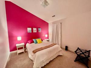 a bedroom with a pink wall and a bed at Lovely Home Near Myrtle Beach in Myrtle Beach