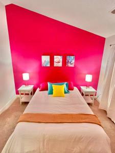 een roze slaapkamer met een groot bed en 2 tafels bij Lovely Home Near Myrtle Beach in Myrtle Beach