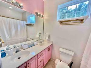 a pink bathroom with a sink and a toilet at Lovely Home Near Myrtle Beach in Myrtle Beach