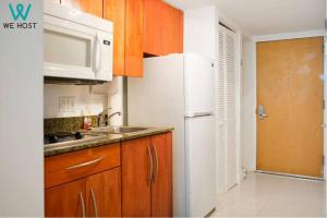 uma cozinha com um frigorífico branco e um lavatório em Fascinating Studio Apt at Brickell em Miami