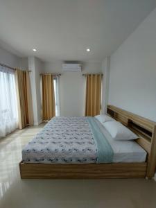 a bedroom with a large bed in a room at Pat Holiday Home in Cha Am