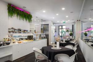 a restaurant with tables and white chairs and a counter at Hotel Luxe in Split