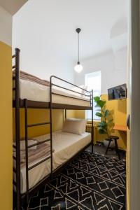 um quarto com beliches e uma parede amarela em JUST KOLONAKI em Atenas