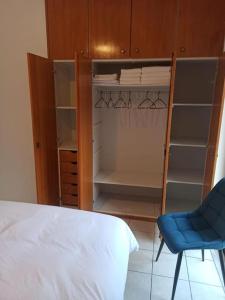 - une chambre avec un lit, une chaise bleue et des étagères dans l'établissement Urban Mountain House, à Karpenísi