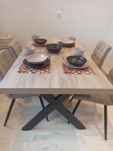a wooden table with bowls and plates on it at Urban Mountain House in Karpenision