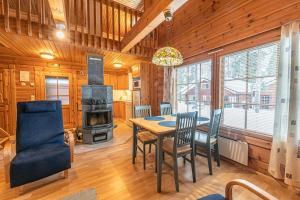a dining room with a table and chairs and a stove at Chalet cheminee sauna PAS DE DRAP PAS DE SERVIETTE MENAGE COMPRIS in Sirkka