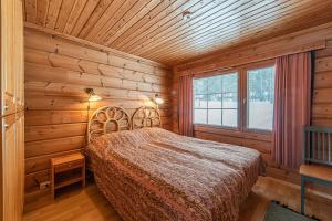 a bedroom with a bed in a wooden room at Chalet cheminee sauna PAS DE DRAP PAS DE SERVIETTE MENAGE COMPRIS in Sirkka