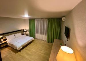 Ένα ή περισσότερα κρεβάτια σε δωμάτιο στο Green Hotel ANG