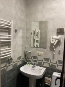 bagno con lavandino e specchio di ART family hotel a Tbilisi City